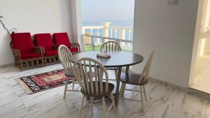 a dining room with a table and chairs and a balcony at Wadi shab Rose Beach in Sur