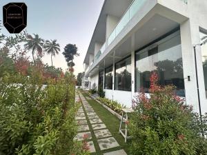 un edificio con plantas delante de él en Golden Pearl Resort By Gemstone Hospitality, en Alībāg