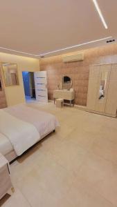 een grote slaapkamer met een bed en een bureau bij شـاليــه غـيــم in Riyad