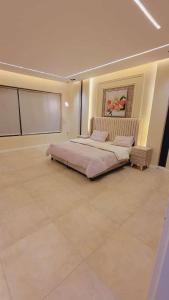 een slaapkamer met een groot bed in een kamer bij شـاليــه غـيــم in Riyad