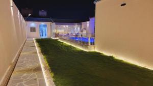 une maison avec une pelouse verte à côté d'un bâtiment dans l'établissement شـاليــه غـيــم, à Riyad