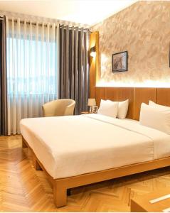 um quarto com uma cama grande e uma janela em Tirana International Hotel & Conference Center em Tirana