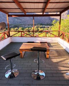a patio with a wooden table and two stools at Hostal Al Yaras in Coquimbo