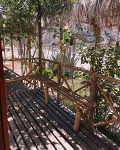 un banco de madera sentado junto a una valla en Hostal Al Yaras en Coquimbo