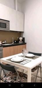 un tavolo bianco con due sedie e una cucina di Loft Bacchiglione a Milano