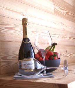 una bottiglia di vino e un cesto di frutta su un tavolo di Vetta Alpine Relax a Livigno