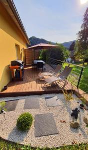 a patio with a table and chairs and a grill at Adossée à la colline in Willer-sur-Thur