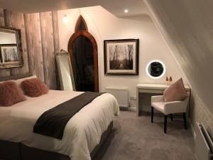 um quarto com uma cama grande e uma cadeira em Old Schoolhouse, Galgorm (Annexe) em Galgorm