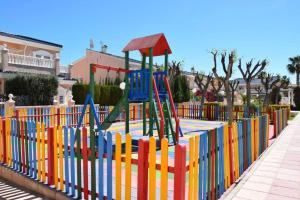 een speeltuin met een kleurrijke speeluitrusting in een park bij Gran Alicante Bungalow in Beach Resort in Puerto Marino