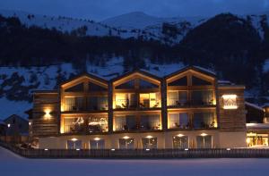 un grande edificio con luci accese nella neve di Vetta Alpine Relax a Livigno