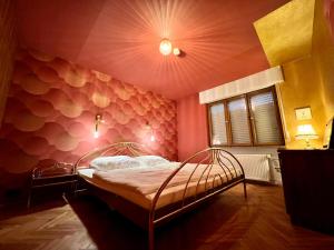 a bedroom with a bed with a pink wall at Hessestub in Wächtersbach
