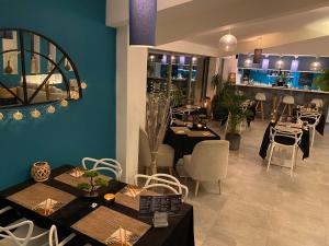 a restaurant with tables and chairs and a blue wall at Hotel La Voile in Bormes-les-Mimosas