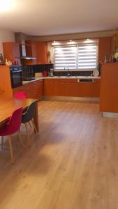 a large kitchen with wooden floors and a table at Adossée à la colline in Willer-sur-Thur