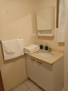 baño con lavabo y armario blanco en Hostal Al Yaras en Coquimbo