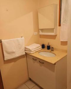 baño con lavabo y toalla blanca en Hostal Al Yaras en Coquimbo