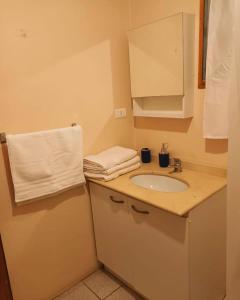 a bathroom with a sink and a white towel at Hostal Al Yaras in Coquimbo