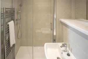a bathroom with a sink and a glass shower at 2 Double Beds - 2 Single Beds in Manchester
