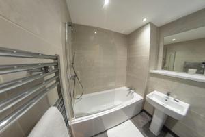 a bathroom with a shower and a tub and a sink at 2 Double Beds - 2 Single Beds in Manchester