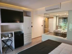 baño grande con TV y lavabo en Mar Azul Suites Apart Boutique en Balneario Mar Azul