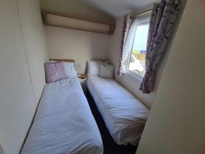 ファイリーにあるHappy Days Caravan Primrose Valleyの窓付きの小さな部屋のベッド2台