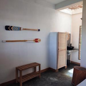a room with a wall with two baseball bats and a refrigerator at KIBA HOTEL in Hell-Ville