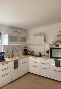 a white kitchen with white cabinets and appliances at Aufatmen in Ahlbeck in Ahlbeck