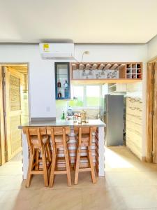 una cocina con una gran isla de madera con taburetes de bar en Apartamento - suite, Frente al mar en San Silvestre