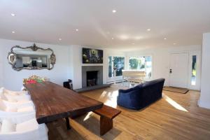 uma sala de estar com uma mesa, um sofá e uma lareira em Modern 3BR 2BA Home w Patio Outdoor Salt Pool em East Hampton