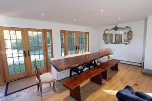 uma sala de jantar com uma grande mesa de madeira e cadeiras em Modern 3BR 2BA Home w Patio Outdoor Salt Pool em East Hampton