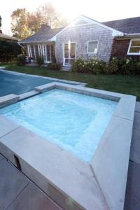 a large swimming pool in front of a house at Modern 3BR 2BA Home w Patio Outdoor Salt Pool in East Hampton