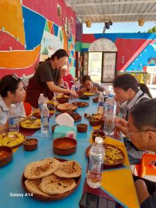 un grupo de personas sentadas en una mesa comiendo comida en Kamel House en Asuán
