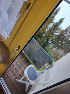 einen Stuhl auf einer Veranda neben einem Fenster in der Unterkunft GROẞE und ZENTRALE Ferienwohnung in KÖLN nähe Messe und Lanxess Arena in Köln