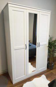- une armoire blanche avec un miroir dans l'établissement Luxury and Central Apartment in Cologne !!, à Cologne