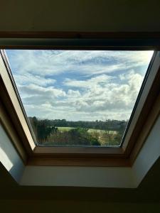 une lucarne avec vue sur un champ dans l'établissement The Loft @ Kildare Village, à Kildare