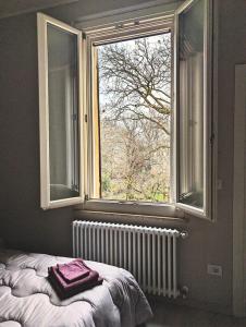 Ce lit se trouve dans un dortoir doté d'une fenêtre et d'un radiateur. dans l'établissement Maison del Ducato Suite Parmigianino, à Parme