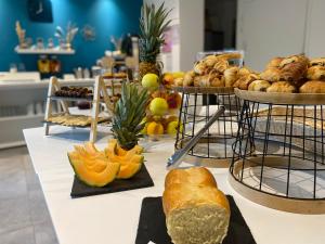 a table filled with different types of bread and pastries at Hotel La Voile in Bormes-les-Mimosas