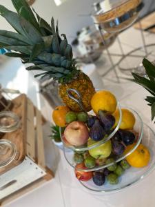 a bowl of fruit on a counter with a pineapple at Hotel La Voile in Bormes-les-Mimosas