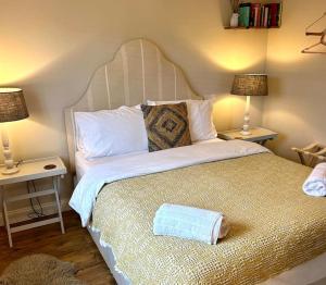 a bedroom with a large bed with two lamps at Cargibbitt Annexe in Liskeard