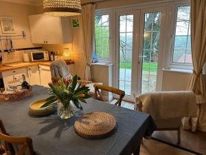 a kitchen with a table with a vase of flowers on it at Cargibbitt Annexe in Liskeard