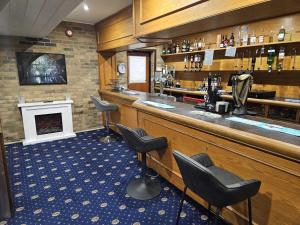 a bar with black chairs and a fireplace at Dolphin Hotel St Ives in St. Ives