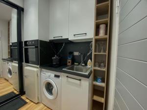 een keuken met een wastafel en een wasmachine bij Tirana Elegant Apartment in Tirana