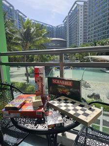 uma mesa com um tabuleiro de xadrez no topo de uma varanda em Cozy Staycation - Azure Urban Resort Residences em Manila