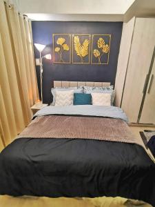 um quarto com uma cama grande e paredes azuis em Cozy Staycation - Azure Urban Resort Residences em Manila