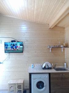 een keuken met een wasmachine en een tv aan de muur bij Hotel sauna in Poti