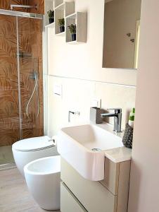 La salle de bains est pourvue d'un lavabo et de toilettes. dans l'établissement Maison del Ducato Suite Parmigianino, à Parme