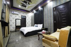 um quarto de hotel com uma cama e um sofá em Karachi Guest House Johar em Carachi
