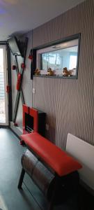 una palestra con una panca rossa in una stanza di LOVE ROOM Cabane des charmes a Andernos-les-Bains