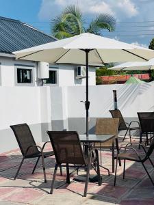 a table and chairs with an umbrella on a patio at Andromeda Executive Lodge in Ndola