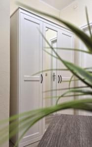 Al Glicine Apartments في لازيسي: صف من الخزانات البيضاء في الغرفة