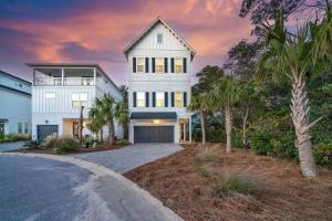 a white house with palm trees and a driveway at Spacious home 1/2 mile to beach - Bikes - Fire Pit Table - Beach Gear - Infinity Table in Inlet Beach